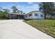 An inviting home with a convenient carport, screened porch, and a sloping front lawn at 11409 Spring Hill Dr, Spring Hill, FL 34609