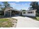 Charming home featuring a covered carport, screened porch, and a well-maintained front yard at 11409 Spring Hill Dr, Spring Hill, FL 34609
