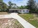 Aerial view of a well-maintained home showcasing the front yard, driveway, and lush surrounding landscape at 11409 Spring Hill Dr, Spring Hill, FL 34609