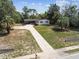 An aerial view shows the front yard, palm trees and long driveway of a beautiful property at 11409 Spring Hill Dr, Spring Hill, FL 34609