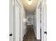 Neutral hallway features tile flooring, clean white doors, and a globe light fixture at 11409 Spring Hill Dr, Spring Hill, FL 34609