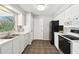 Kitchen boasts white cabinetry, tile floor, black appliances, and ample counter space at 11409 Spring Hill Dr, Spring Hill, FL 34609