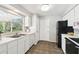 Kitchen boasts white cabinetry, tile floor, black appliances, and a double basin sink at 11409 Spring Hill Dr, Spring Hill, FL 34609