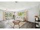 Inviting living room featuring two large windows, hardwood floors, a comfortable sofa, and chic, neutral decor at 11409 Spring Hill Dr, Spring Hill, FL 34609