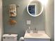 Bathroom features a round mirror, seashell themed towels, and a toilet at 120 1St E St # 104, St Petersburg, FL 33715