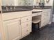 Bathroom featuring dual sinks, a vanity area, a large mirror, and white cabinets with dark countertops at 120 1St E St # 104, St Petersburg, FL 33715