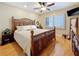 Traditional bedroom boasts hardwood floors, a ceiling fan, a window with blinds, and dark wood furniture at 120 1St E St # 104, St Petersburg, FL 33715