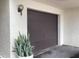 Exterior view of a single-car garage door and a tropical snake plant at 120 1St E St # 104, St Petersburg, FL 33715
