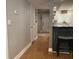 Hallway with hardwood floors that lead to the kitchen and living room area with grey walls and white trim at 120 1St E St # 104, St Petersburg, FL 33715