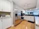 Bright kitchen featuring stainless steel appliances, white cabinetry, and wood-look flooring at 120 1St E St # 104, St Petersburg, FL 33715