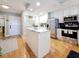Bright kitchen with stainless appliances, white island and shaker cabinets, on hardwood floors at 120 1St E St # 104, St Petersburg, FL 33715