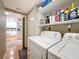 Laundry room featuring full-sized washer and dryer, shelves for storage, and an open view to the kitchen at 120 1St E St # 104, St Petersburg, FL 33715