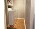 This laundry room features white walls, wood floors and a white washing machine and dryer at 120 1St E St # 104, St Petersburg, FL 33715