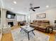 Bright living room featuring hardwood floors, a ceiling fan, a fireplace with TV, a leather sofa set and lots of light at 120 1St E St # 104, St Petersburg, FL 33715