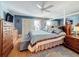 Beautiful main bedroom featuring a ceiling fan, a large mirror wall, a light blue quilt, and wood furniture at 120 1St E St # 104, St Petersburg, FL 33715