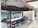 Outdoor seating with a thatched palapa roof with tennis courts in the background at 120 1St E St # 104, St Petersburg, FL 33715