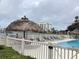 Tranquil waterfront pool area featuring lounge chairs, tiki umbrellas, and stunning views at 120 1St E St # 104, St Petersburg, FL 33715