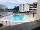 Inviting waterfront pool area with clear blue water, poolside seating, and tiki umbrellas at 120 1St E St # 104, St Petersburg, FL 33715
