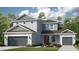 Charming two-story home with a well-manicured lawn, gray siding, and a welcoming front entrance at 1759 Longliner Loop, Wesley Chapel, FL 33543