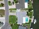 Aerial of backyard with pool and boat dock on canal; grey roof, green lawn at 1769 Brookside Blvd, Largo, FL 33770