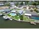 Aerial view of waterfront home featuring a private pool, lush landscaping, and a boat dock for waterfront living and recreation at 1769 Brookside Blvd, Largo, FL 33770