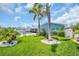 Landscaped backyard featuring a well-maintained lawn, palm trees, and a pool area, creating a serene outdoor oasis at 1769 Brookside Blvd, Largo, FL 33770