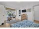 Well-lit bedroom featuring wood floors, patio access, closet, TV, and stylish decor at 1769 Brookside Blvd, Largo, FL 33770