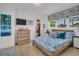 Inviting bedroom with wood floors, closet, bright windows and a tropical patterned bedspread at 1769 Brookside Blvd, Largo, FL 33770
