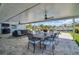 Outdoor dining space on a covered patio, featuring a dining table, chairs, and ceiling fans, perfect for entertaining by the pool at 1769 Brookside Blvd, Largo, FL 33770