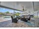 Covered patio with comfortable seating and ceiling fans, overlooking the sparkling pool and waterfront views for outdoor relaxation at 1769 Brookside Blvd, Largo, FL 33770