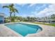 Sparkling swimming pool surrounded by a tiled patio and lush greenery, perfect for enjoying the outdoors and waterfront living at 1769 Brookside Blvd, Largo, FL 33770