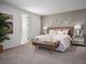 Comfortable bedroom featuring a large bed with mirrored nightstands, art and a bench at 1856 Draughton Dr, Zephyrhills, FL 33541