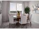 Dining area with wood table, four chairs, decorative vases and a large window at 1856 Draughton Dr, Zephyrhills, FL 33541
