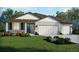 Charming home features a landscaped yard, neutral paint, shingled gable and a two-car garage at 1856 Draughton Dr, Zephyrhills, FL 33541
