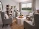 Inviting living room with four armchairs, a round rug, bookshelf and a scenic window view at 1856 Draughton Dr, Zephyrhills, FL 33541
