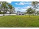 A sprawling, fenced backyard with lush green grass and mature trees at 1948 Grenville Ct, Wesley Chapel, FL 33543