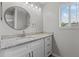 Bathroom featuring granite countertop, vanity, and large, round mirror at 1948 Grenville Ct, Wesley Chapel, FL 33543