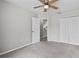 A well-lit bedroom with carpet, a ceiling fan, and a double door closet at 1948 Grenville Ct, Wesley Chapel, FL 33543