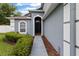 Inviting front entrance featuring an arched doorway, lush bushes, and exterior lighting at 1948 Grenville Ct, Wesley Chapel, FL 33543