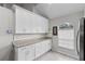 Bright kitchen features white cabinetry, subway tile backsplash and granite countertops at 1948 Grenville Ct, Wesley Chapel, FL 33543