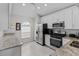 Modern kitchen with white cabinets, stainless steel appliances, and ample counter space at 1948 Grenville Ct, Wesley Chapel, FL 33543