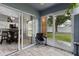Enclosed lanai with tile flooring, screen door leading to backyard, and sliding door to the interior at 1948 Grenville Ct, Wesley Chapel, FL 33543