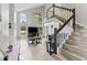 Spacious living area with high ceilings, large windows, and access to the staircase at 1948 Grenville Ct, Wesley Chapel, FL 33543
