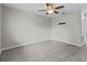 A spacious living room with gray walls, wood flooring, and a ceiling fan at 1948 Grenville Ct, Wesley Chapel, FL 33543