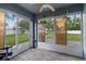 Sunroom with tile flooring, white framed windows, and view of backyard at 1948 Grenville Ct, Wesley Chapel, FL 33543