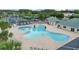 Community swimming pool with blue umbrellas, tables, lounge chairs, and meticulously maintained landscaping at 1948 Grenville Ct, Wesley Chapel, FL 33543