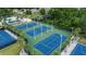 Aerial view of community tennis courts and the meticulously maintained landscaping surrounding them at 1948 Grenville Ct, Wesley Chapel, FL 33543