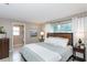 Calm bedroom with a large window, ensuite bathroom, and soothing blue accents on the bed at 2012 Scotland Dr, Clearwater, FL 33763