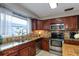 Kitchen features granite countertops, tile backsplash, stainless steel appliances, and natural light at 2012 Scotland Dr, Clearwater, FL 33763