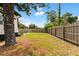 A fenced backyard with a mix of grassy areas and pine straw, offering privacy and space at 2306 Trelain S Dr, St Petersburg, FL 33712
